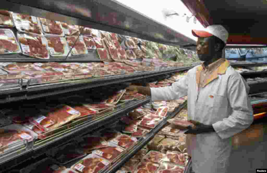 A shop worker arranges packaged meat at a leading supermarket in Harare January 16, 2012. Zimbabwe's headline consumer inflation rate quickened to 4.9 percent year-on-year in December, higher than government's year-end target for 2011.