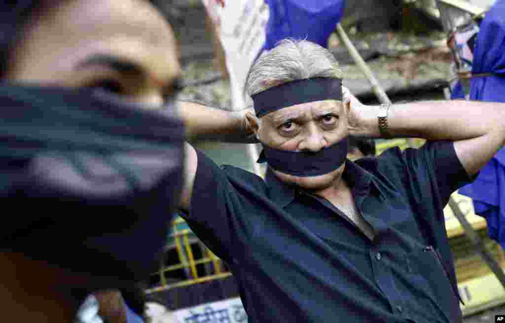 An Indian ties a black band as he arrives to attend a gathering to mourn the death of a 23-year-old gang rape victim, in Mumbai, Saturday, Dec. 29, 2012.