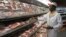 FILE: A shop worker arranges packaged meat at a leading supermarket in Harare January 16, 2012. Zimbabwe's headline consumer inflation rate quickened to 4.9 percent year-on-year in December, higher than government's year-end target for 2011.