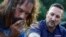 FILE - Pastor Jamie Casey, right, speaks with Brian Peets at a homeless camp in New Bedford, Mass., Aug. 10, 2018.