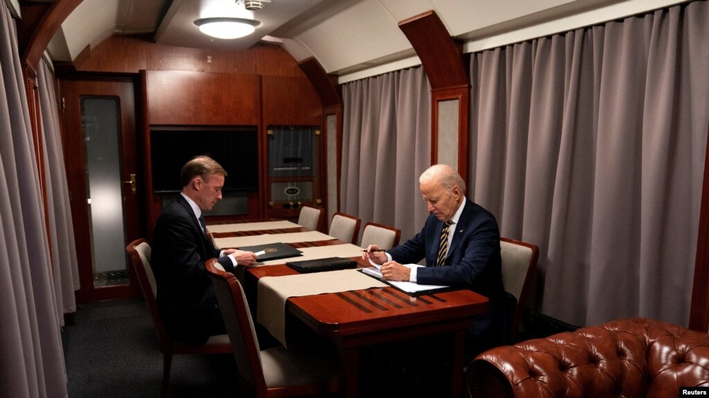 El presidente Joe Biden (derecha) sentado en un tren con el asesor de Seguridad Nacional Jake Sullivan mientras repasa su discurso con motivo del primer aniversario de la guerra en Ucrania, el lunes 20 de febrero de 2023, antes de llegar a Kiev. 