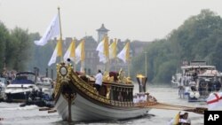 ເຮືອບັນທຸກຮາງໄຟ Gloriana ຂອງກະສັດ ທີ່ມີທວນໄຟກິລາ​ໂອ​ລິ​ມປິກໃນຂະນະທີ່ມຸງໜ້າໄປຫາແມ່ນໍ້າ Thames ເພື່ອກຽມລໍຖ້າພິທີເປີດກິລາໂອລິມປິກທີ່ນະຄອນຫລວງລອນດອນ ໃນແລງວັນທີ 27 ກໍລະກົດ, 2012. 