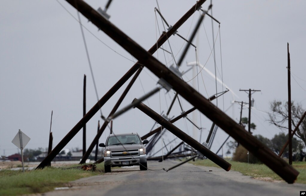 德克萨斯州塔夫脱，飓风刮倒的电线杆像是组成了迷宫，汽车在其中穿行。（8月26日）