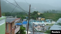 FILE - Houses from a seaside neighborhood are seen as Tropical Storm Karen approaches in Naguabo, Puerto Rico, Sept. 24, 2019.