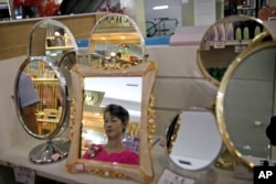 A staff member is reflected in a mirror for sale at the Potonggang department store in Pyongyang, North Korea, June 19, 2017.