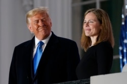 FILE - President Donald Trump and Amy Coney Barrett stand on the Blue Room Balcony after Supreme Court Justice Clarence Thomas administered the Constitutional Oath to her on the South Lawn of the White House, Oct. 26, 2020.