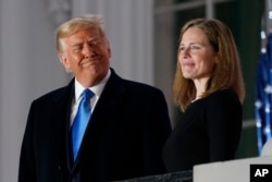 President Donald Trump and Amy Coney Barrett stand on the Blue Room Balcony after Supreme Court Justice Clarence Thomas administered the Constitutional Oath on Oct. 26, 2020.