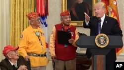 FILE - President Donald Trump speaks during a meeting with Navajo Code Talkers Fleming Begaye, seated at left, Thomas Begay, second from left, and Peter MacDonald in the Oval Office of the White House, Nov. 27, 2017. Begaye died May 10, 2019, in Arizona at 97. 