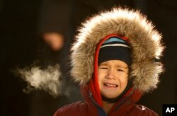 Theo Bradeen, 5, of reacts to the cold as he disembarks from a ferry after a ride from his home on Peaks Island to Portland, Maine, Dec. 16, 2016.