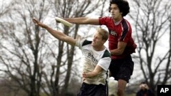 Colin Mahoney of the Brown University scores a point as he leaps over Dartmouth's Andrew Hoffman at the New England Regional Ultimate Frisbee Tournament in Portsmouth, RI, May 1, 2005. 