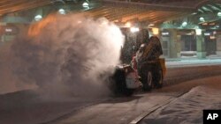 Un trabajador en el aeropuerto internacional Albany, en Colonie, N.Y., limpia la nieve el domingo 20 de enero de 2019, después que una tormenta invernal que cubrió de nieve la mayor parte del centro occidente de EE.UU. avanzó a Nueva Inglaterra el sábado.