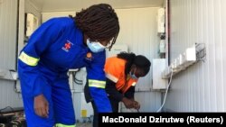 Karyawan mengisi baterai lithium ion untuk sepeda motor listrik Hamba di stasiun pengisian tenaga surya di Wedza, Zimbabwe, 22 Mei 2020. (Foto: Reuters/MacDonald Dzirutwe)