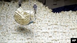 In this June 29, 2007 file photo, South Korean workers load packs of rice for North Korea into a Vietnamese ship at Gunsan port in Gunsan, South Korea. 