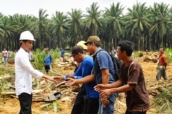 Presiden Jokowi menyalami petani sawit di tengah kunjungannya ke Rokan Hulu, Riau. (Foto: Humas Setneg)