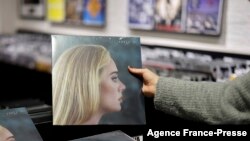 A member of staff sorts copies of the new album from British singer-songwriter Adele, "30" in Sister Ray record store in the soho area of central London, Nov. 19, 2021. 