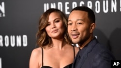 FILE - John Legend, executive producer of "Underground," poses with his wife Chrissy Teigen at the season two premiere of the television series.
