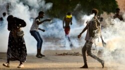 Sudanese youths confront security forces amidst tear gas fired by them to disperse protesters in the capital Khartoum, on Oct. 27, 2021, amid ongoing demonstrations against a military takeover that has sparked widespread international condemnation.