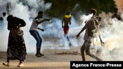 Sudanese youths confront security forces amidst tear gas fired by them to disperse protesters in the capital Khartoum, on Oct. 27, 2021, amid ongoing demonstrations against a military takeover that has sparked widespread international condemnation.