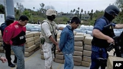 Soldiers and police officers escort detainees after a conjoined operation with the army, local and state police seized 105 tons of U.S.-bound marijuana in Tijuana, Mexico, 18 Oct 2010