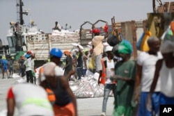 FILE - Workers offload goods from a docked ship at the seaport of Berbera in Somaliland, a breakaway region of Somalia, on Feb. 10, 2022.