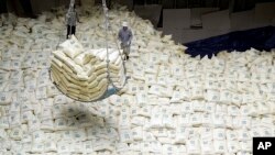 In this June 29, 2007 file photo, South Korean workers load packs of rice for North Korea into a Vietnamese ship at Gunsan port in Gunsan, South Korea. A group of humanitarian activists are sending rice, medicine and information in bottles to North Korea.