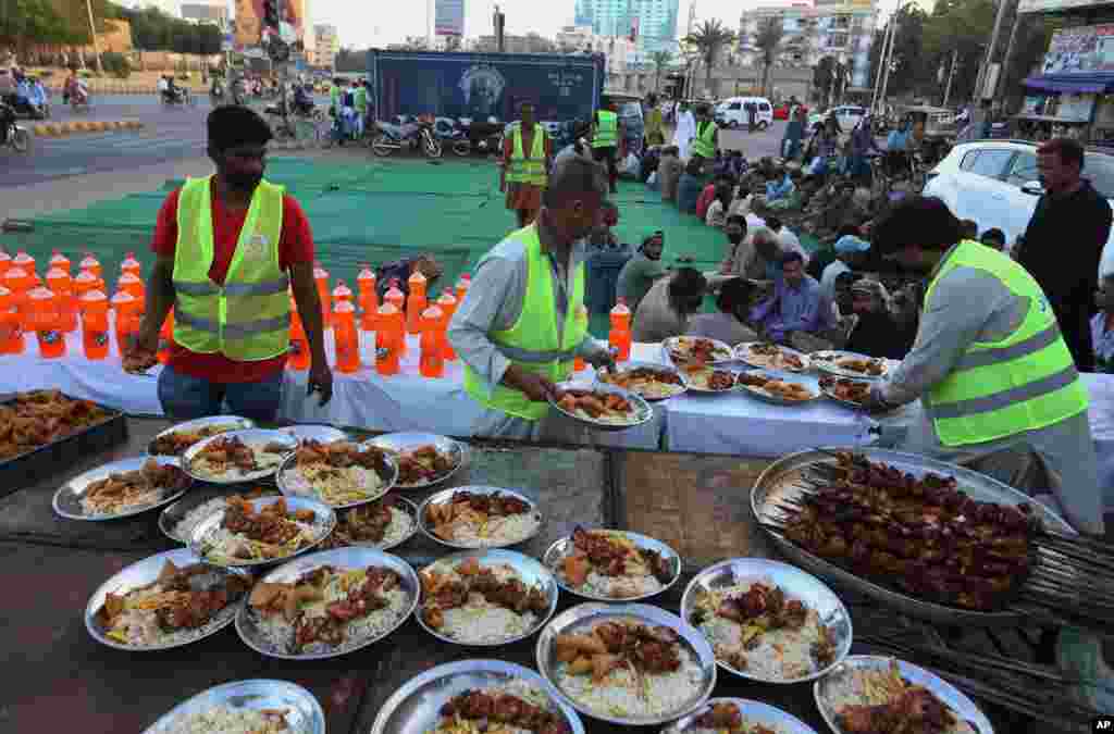 داوطلبان در حال آماده کردن ظروف وعده‌های غذای افطاری برای پخش کردن بین روزه‌داران در کراچی، پاکستان