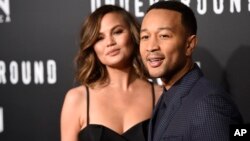 FILE - John Legend, executive producer of "Underground," poses with his wife Chrissy Teigen at the season two premiere of the television series.