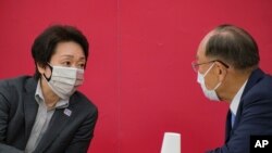 President of the Tokyo 2020 Organizing Committee of the Olympic and Paralympic Games Seiko Hashimoto, left, talks with Canon CEO and Honorary Chairman Fujio Mitarai before a Tokyo 2020 executive board meeting in Tokyo, May 26, 2021. 