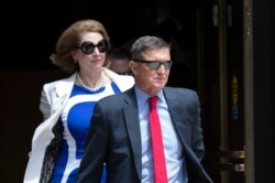 FILE - Former national security adviser Michael Flynn, right, and his lawyer, Sidney Powell, leaves the federal courthouse in Washington, June 24, 2019.