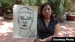 Luật sư Nguyễn Thị Dương Hà cầm bức tranh tự hoạ của TS luật Cù Huy Hà Vũ 1 ngày trước khi ông tuyệt thực. TS Vũ đã tuyệt thực hơn 18 ngày trong nhà tù.