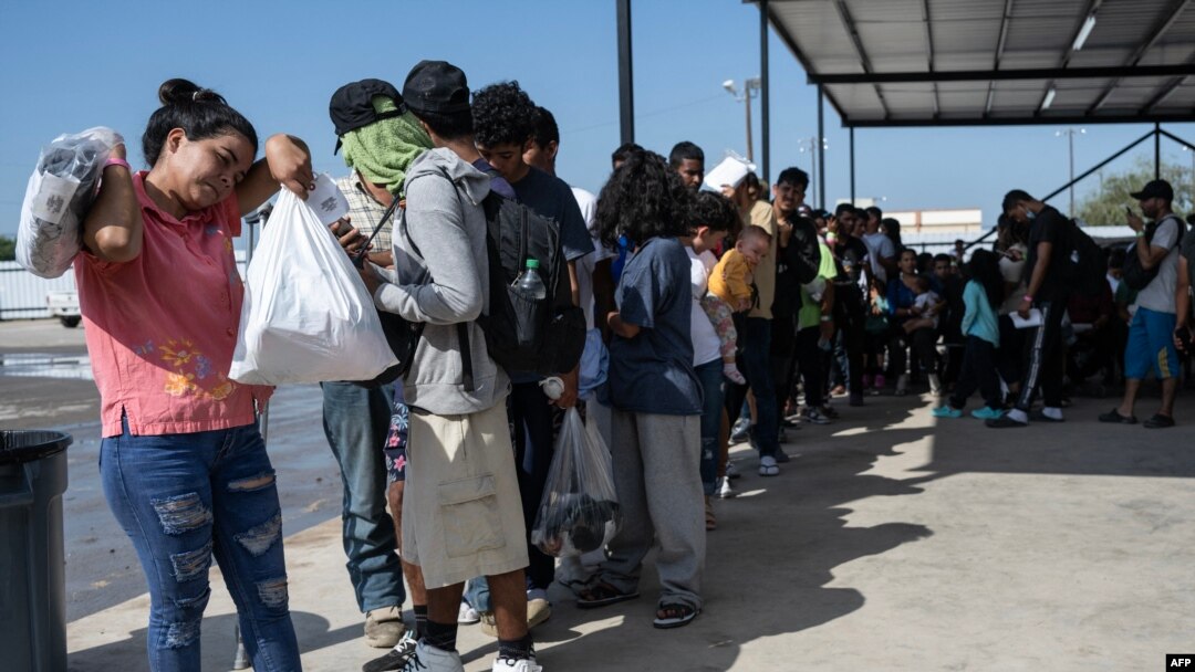 Los migrantes hacen fila mientras esperan un autobús a Chicago para transportarlos fuera de Eagle Pass, Texas, el 26 de septiembre de 2023, en el complejo Mission Border Hope.