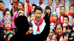 在北京展览馆前面，人们前往参观《砥砺奋进的五年》大型成就展里有中国主席习近平带着少先队的红领巾和少年儿童的合影（2017年10月23日）