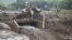 FILE - People cross a bridge broken by heavy rains and landslides in the village of Sebit, West Pokot County, Kenya, Nov. 24, 2019.