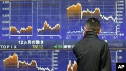 A man looks at a stock quotation board outside a brokerage in Tokyo, December 12, 2011.