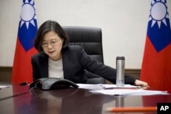 FILE - Taiwan's President Tsai Ing-wen speaks with U.S. President-elect Donald Trump through a speaker phone in Taipei, Taiwan.