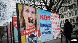 A campaign poster showing gagged Swiss MP Celine Amaudruz of right wing populist Swiss People's Party and asking voters in a referendum to reject a proposed ban on discrimination based on sexual orientation, is seen in Geneve, Switzerland, Jan. 30, 2020.