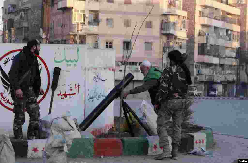 Free Syrian Army fighters prepare to launch a mortar towards fighters from the Islamic State in Iraq and the Levant from a street in the Kadi Askar neighborhood of Aleppo, Jan. 7, 2014. 