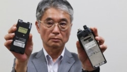 Direktur Icom, Yoshiki Enomoto, menunjukkan walkie-talkie model IC-V82 yang menurut perusahaan pembuat perangkat radio itu, produksinya sudah dihentikan pada 2014, di Osaka, Jepang, Kamis, 19 September 2024. (Foto: Kim Kyung-Hoon/Reuters)