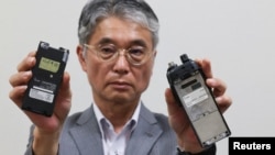 Direktur Icom, Yoshiki Enomoto, menunjukkan walkie-talkie model IC-V82 yang menurut perusahaan pembuat perangkat radio itu, produksinya sudah dihentikan pada 2014, di Osaka, Jepang, Kamis, 19 September 2024. (Foto: Kim Kyung-Hoon/Reuters)