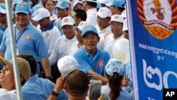 Cambodian Prime Minister Hun Sen, center, greets his supporters during his Cambodian People's Party's last campaign for the July 29 general election, in Phnom Penh, Cambodia, Friday, July 27, 2018. 