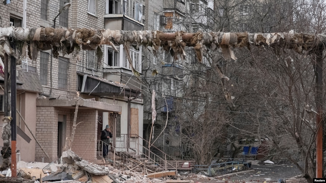 A resident smokes near his apartment building damaged by Russian military strikes, amid Russia's attack on Ukraine, in the frontline town of Pokrovsk in Donetsk region, Ukraine, March 6, 2025.