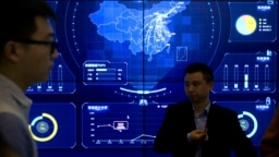 在北京举行的全球移动互联网大会上，参观者站在一个显示中国地图的电子数据显示器前(2018年4月26日)