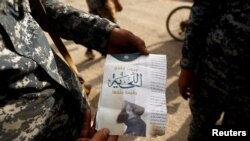 Seorang tentara Irak menunjukkan pamflet ISIS di Mosul, Irak (Foto: dok). Jaksa Federal Jerman telah mendakwa Mikail S., warga Jerman berusia 18 tahun mendukung organisasi teroris dengan menerjemahkan propaganda ISIS.