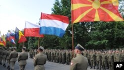 Polish Army soldiers carry flags of some of the countries participating in the Anaconda-16 military exercise, during the opening ceremony, in Warsaw, Poland, Monday, June 6, 2016.