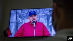 A man watches a televised national address by Nicaraguan President Daniel Ortega, at his home in Managua, June 23, 2021.