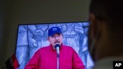 FILE - A man watches a televised national address by Nicaraguan President Daniel Ortega, at his home in Managua, June 23, 2021.