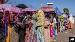 Women who fled the conflict in Ethiopia's Tigray region wait for UNHCR to distribute blankets at Hamdayet Transition Center, eastern Sudan, Nov. 21, 2020.