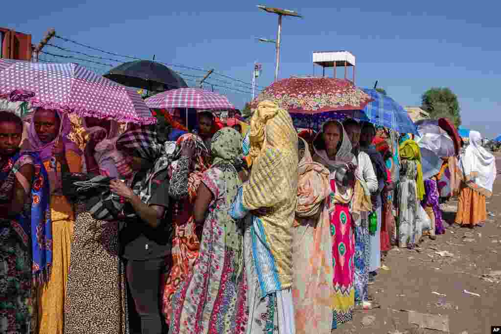 Women who fled the conflict in Ethiopia's Tigray region wait for UNHCR to distribute blankets at Hamdayet Transition Center, eastern Sudan, Nov. 21, 2020.