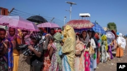 Para perempuan yang menyelamatkan diri dari konflik di wilayah Tigray, Etiopia menunggu bantuan di Pusat Transisi Hamdayet, timur Sudan, 21 November 2020.