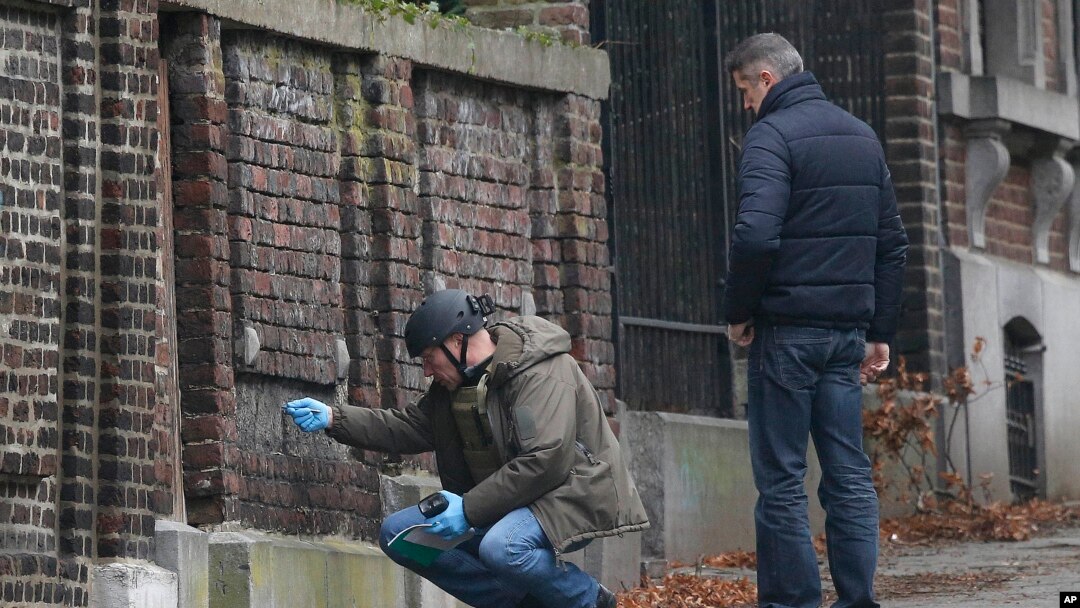 Polisi Belgia meneliti sebuah bangunan di pinggir jalan di Verviers, Belgia (Jumat, 16/1). Jalan itu diblokir setelah polisi berhasil mencegah aksi terorisme sehari sebelumnya yang menewaskan 2 orang dan seorang ditangkap. 